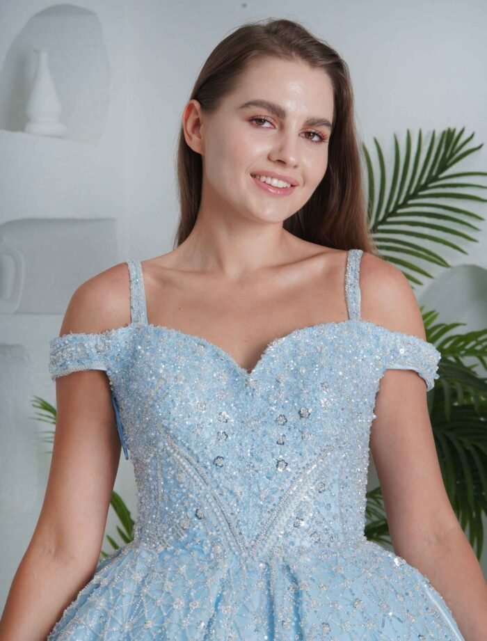 Fairytale-style light blue ball gown with off-shoulder neckline and glitter details.