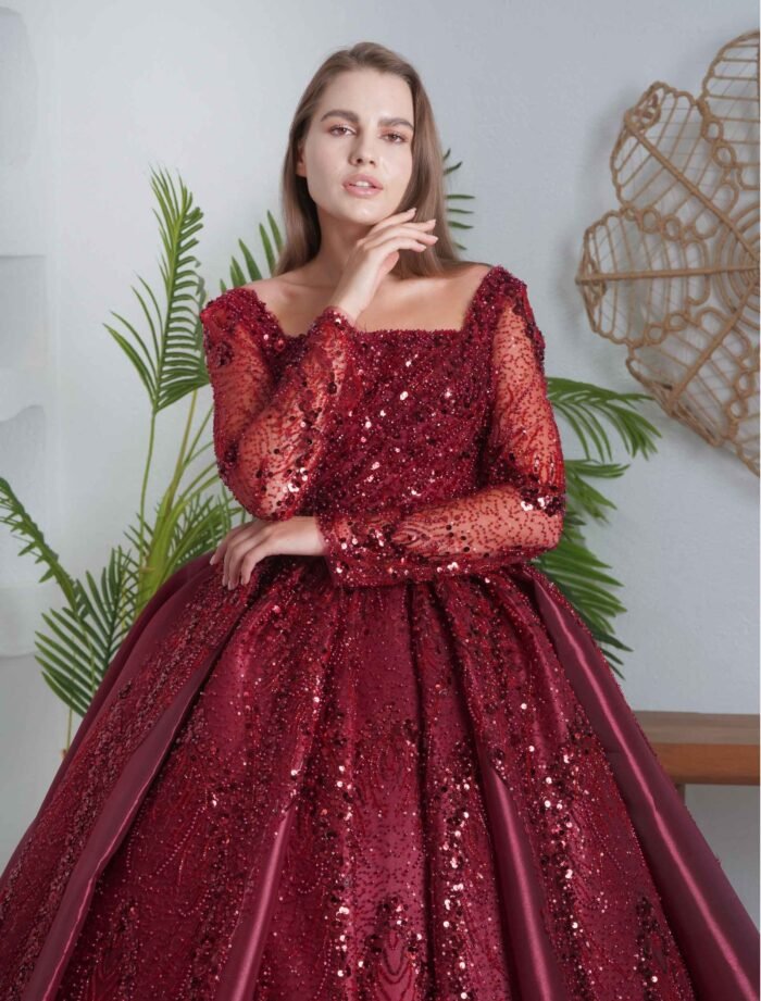 Rich burgundy ball gown with sequin embroidery and long sleeves.